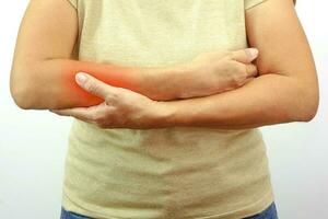Frau mit Schmerzen im Arm auf weißem Hintergrund. gesundheits- und bürosyndromkonzept. foto