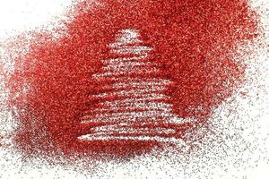 Finger gezeichneter Weihnachtsbaum auf glänzendem rotem Konfettihintergrund foto