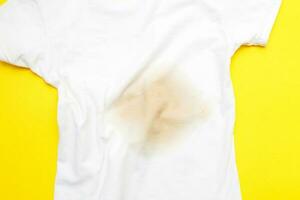 schmutzig beflecken auf ein Weiß Kleider auf Gelb Hintergrund foto