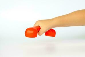 rot Spielzeug Telefon im das Kinder Hand. Nahansicht von ein Kinder Hand. isoliert auf ein Weiß Hintergrund. das Konzept von ein Werbung Banner. foto