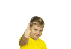 ein Junge im ein Gelb T-Shirt auf ein Weiß Hintergrund Punkte seine Finger beim ein positiv Bewertung. wie. das Konzept von ein Banner mit Information. Raum zum das Text. foto