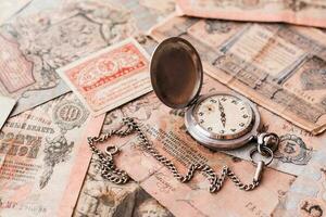Antiquität Uhren auf ein Kette Lüge auf alt Rubel Banknoten aus von Verkehr auf ein braun Hintergrund. foto