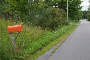 Orange ländlich Briefkasten im ein ländlich Landschaft. foto
