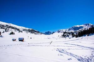 schneebedeckte Dolomiten und Hütten