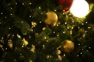 schließen oben Dekoration Ball und Licht Birne auf Weihnachten Baum beim Nacht foto