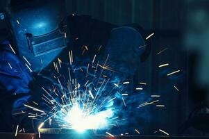 industriell Arbeitskräfte beim Stahl Struktur Schweißen Pflanze ein Schweißer ist Schweißen Metall Teile im ein klein Werkstatt. foto