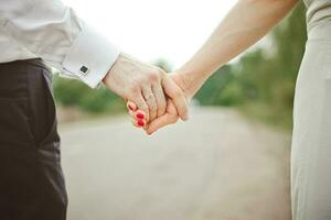 Ein Mann hält die Hand einer Frau. Hände der Braut und des Bräutigams mit einer Eheringnahaufnahme foto