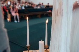 kleiner Hochzeitstisch in Weiß mit Kerzen und Blumen foto