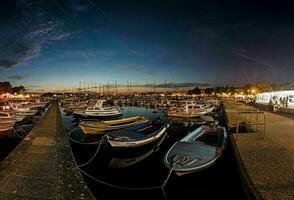 Bild von Boote im das Hafen von das kroatisch Küsten Stadt, Dorf von porec nach Sonnenuntergang im das zuletzt Tageslicht foto