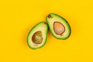Schneiden Sie frische reife Avocado auf gelbem Hintergrund foto