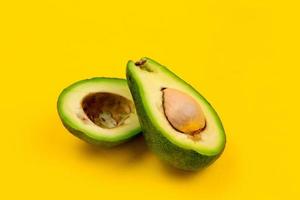 Schneiden Sie frische reife Avocado auf gelbem Hintergrund foto