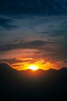 schön Sonnenuntergang Himmel mit Berg Silhouette foto