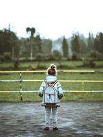 Kind mit Regenjacke und Rucksack. Konzept von zurück zu Schule. ai generiert foto