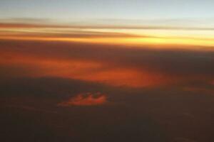 mysteriös Sonnenuntergang mit Wolken von das Flugzeug Fenster mit foto