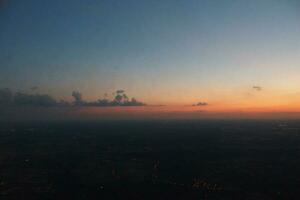 mysteriös Sonnenuntergang mit Wolken von das Flugzeug Fenster mit foto