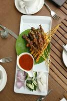 Satay Hähnchen Rindfleisch mit Erdnuss Soße gewürfelt Zwiebel Gurke Ketupat Reis Kuchen foto