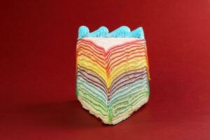 Regenbogen Krepp Schicht Kuchen auf rot Hintergrund foto