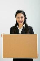 jung asiatisch weiblich tragen passen Sitzung beim Büro Schreibtisch aussehen beim Kamera Kopfhörer Anruf Center foto