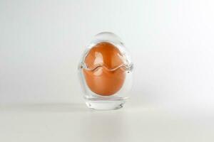 Ei im Ei gestalten Glas Container Schutz Schale auf Weiß Hintergrund Sicherheit Sicherheit foto