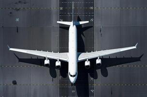 ein oben Antenne Aussicht von ein Flughafen Terminal und Runway mit geparkt kommerziell Flugzeuge Sein geladen mit liefert und Passagiere. Geschäft und Reise. generativ ai. foto