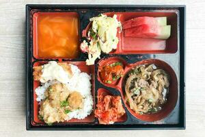 Koreanisch Bento Mittagessen Box Reis Hähnchen Ei Rindfleisch Kimchi Suppe Wassermelone foto