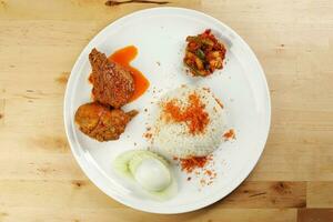 nasi Lemak Reis gekocht mit Kokosnuss Milch Zahnseide mit Curry Hähnchen Sambal Gemüse gekocht Ei Gurke Scheibe foto