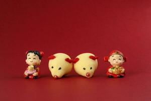 Chinesisch Neu Jahr Ratte Maus geformt Plätzchen Junge Mädchen Puppe auf rot Hintergrund foto