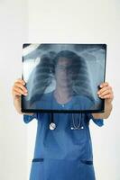 jung asiatisch männlich Arzt tragen Schürze Uniform Tunika Stethoskop halten Sehen x Strahl foto