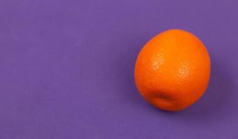 orange Mandarine auf lila Papierhintergrund foto