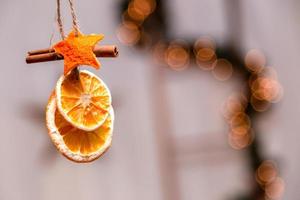 hängende Weihnachtsdekoration von getrockneten Orangen-, Mandarinen- und Zimtsternen mit Kopierraum für Text foto