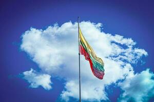 litauisch Flagge auf ein Weiß Wolke im Blau Himmel Hintergrund auf sonnig Tag foto