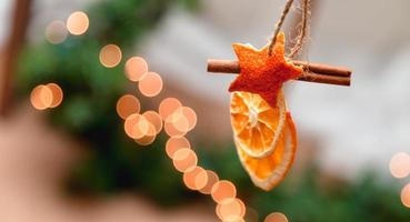 hängende Weihnachtsdekoration von getrockneten Orangen-Mandarinen- und Zimtsternen foto