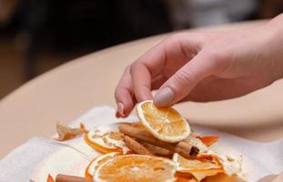 Frauen machen Handdekorationen aus getrockneten Orangen