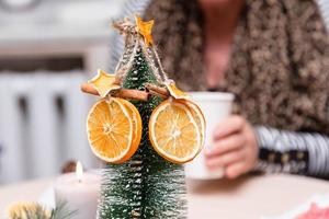 getrocknete orange Sterne von Mandarine und Zimt hängen an einem Weihnachtsbaum