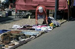 13 kann 2023, Lissabon, Portugal - - Menschen Prüfung das Waren auf Anzeige beim das berühmt feira da ladra - - Floh Markt - - im Lissabon, Portugal. foto