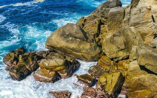 Surfer Wellen Türkis Blau Wasser Felsen Klippen Felsbrocken puerto escondido. foto