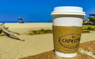 puerto escondido Oaxaca Mexiko 2023 Kaffee zu gehen Becher auf das Strand Sand Meer Wellen. foto