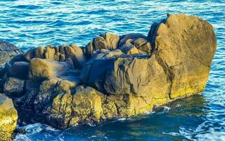 Surfer Wellen Türkis Blau Wasser Felsen Klippen Felsbrocken puerto escondido. foto