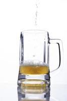 gießen Sie Bier in ein Glas auf weißem Hintergrund für internationale Biertage foto