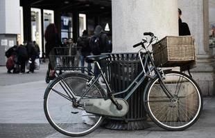 blaues Stadtfahrrad geparkt neben brauner Holzbank foto