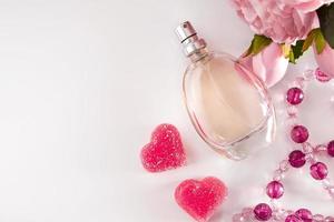 Flasche Parfüm Blumen und Herzen auf einem hellen Hintergrund foto