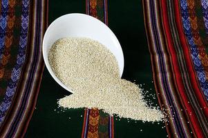 weißes Quinoakorn weißes Quinoakorn in einer weißen Platte auf einem Inka-Mantel foto