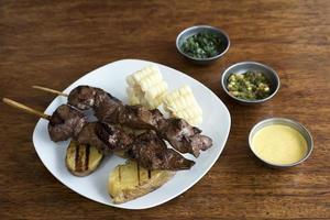 Anticuchos peruanische Küche gegrilltes Fleischfleischspieß mit gekochter Kartoffel und weißem Mais foto