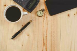 Brunnen Stift und heiß Kaffee auf Holz Tisch.Büro Werkzeug. foto