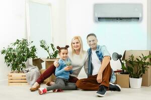 Luft Konditionierung im Leben Zimmer mit glücklich Familie ziehen um zu Neu Wohnung foto