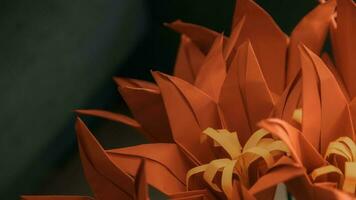 ein schließen oben von ein Origami Blume mit Orange Blätter foto