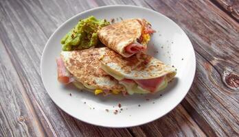 ein Teller von Essen mit ein Quesadilla und Guacamole auf Es. foto