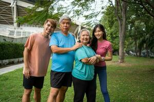 gesund Familie Gruppe Ausbilder trainieren im frisch Luft, und Sie sich ausruhen und Stand zusammen nach Morgen Übungen im Park. draussen Aktivitäten, gesund Lebensstil, stark Körper, passen Zahlen, Gesundheit Pflege. foto