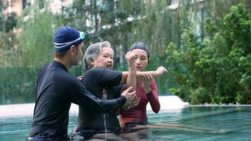 jung Trainer Portion Senior Frau im aqua Aerobic und Arbeiten aus im das Schwimmbad. alt Frau und reifen Mann tun aqua Aerobic Übung im Schwimmen Schwimmbad, Alten Sport, und aktiv Lebensstil Konzept. foto