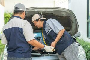 zwei Auto Handwerker prüft das Motor und Kühlung System Vor Reisen auf ein lange Urlaub. Konzept von Auto Pflege und Instandhaltung von Experten, Coaching, und Rat zum üben ein Auto von ein Experte foto